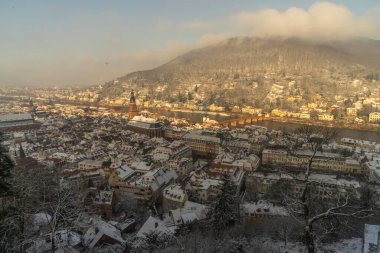 Heidelberg sokaklarında kar ve nehir manzarasıyla yürüyorum.