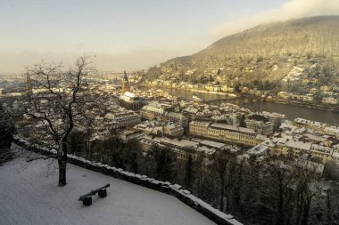 Heidelberg sokaklarında kar ve nehir manzarasıyla yürüyorum.