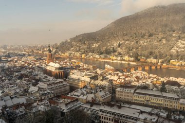 Heidelberg sokaklarında kar ve nehir manzarasıyla yürüyorum.