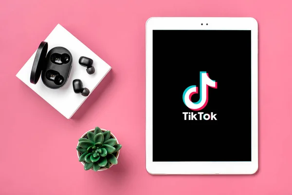 stock image Bangkok, Thailand. October 2022 Tablet Tik Tok application icon, logo on screen and wireless headphones on colorful background Trendy social media network concept Flat lay Top view.