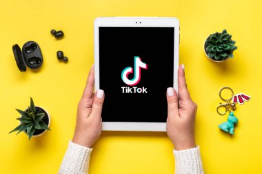 Bangkok, Tayland. Ekim 2022 Tablet Tik Tok uygulama simgesi, ekranda logo ve renkli arka planda kablosuz kulaklık Moda Sosyal medya ağı konsepti Düz.