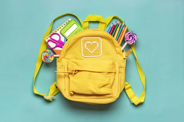 stock image Back to school, education concept Yellow backpack with school supplies - notebook, pens, eraser rainbow, numbers isolated on blue background Top view Copy space Flat lay composition Banner.