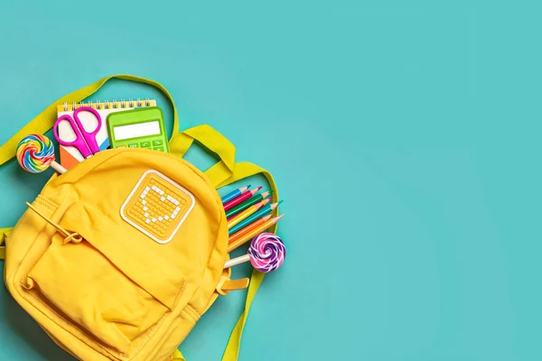 stock image Back to school, education concept Yellow backpack with school supplies - notebook, pens, eraser rainbow, numbers isolated on blue background Top view Copy space Flat lay composition Banner.