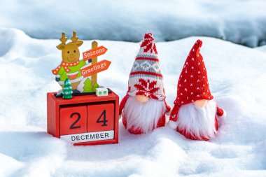 24 Aralık tarihli küp takvimi, İskandinav cüceleri ve karlı orman yılbaşı yılbaşı kartlarında Noel dekoru..