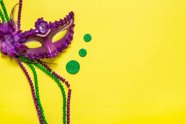 Mardi gras lettering. Congratulation card with violet mask on yellow background Top view 2023 Mardi Gras Parade Schedule Mockup Copy space.