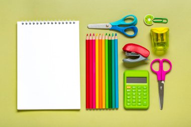 Frame from school and office supplies Paper clips, pens, calculator, sharpener, notepad, stapler isolated on green background Flat lay Top view Back to school, education concept Mock up Copy space.