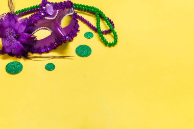 Mardi gras lettering. Congratulation card with violet mask on yellow background Top view 2023 Mardi Gras Parade Schedule Mockup Copy space.