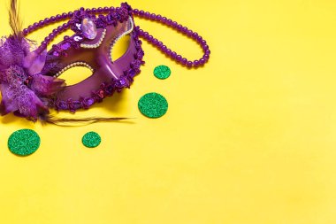 Mardi Gras harfleri. Sarı arka planda menekşe maskeli tebrik kartı. Üst görünüm 2023 Mardi Gras Geçit Töreni Taklit Modülü Mekan Kopyalama.