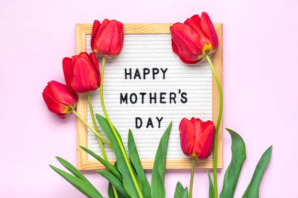 Mutlu Anneler Günleri, pembe arka plan tebrik kartında kırmızı laleler Düz görünüm.