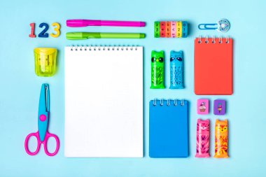 Sabit, okula dönüş, yaratıcılık ve eğitim konsepti. Malzemeler - makas, kalem, ataç, not, zımba, hesap makinesi, yeşil arkaplan üzerine not defteri.