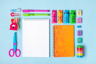 Sabit, okula dönüş, yaratıcılık ve eğitim konsepti. Malzemeler - makas, kalem, ataç, not, zımba, hesap makinesi, yeşil arkaplan üzerine not defteri.