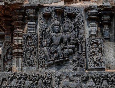 Hindu tanrılarının karmaşık oymaları ve ayrıca Halebidu Hindu tapınağındaki Hint destanlarından sahneler tasvir ediyor. Hindistan.