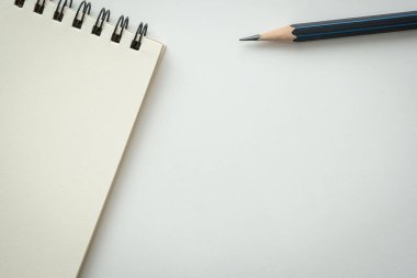 Beyaz zemin üzerinde siyah kalem olan boş spiral bir defter aç. Metnin için Boş Boşluk.
