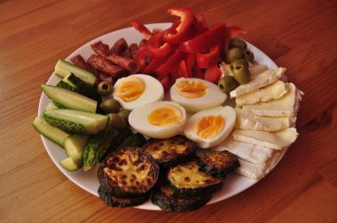 Low-Carb Keto Meal with Eggs, Cheese, Cucumbers, Olives, Sausage, and Red Peppers clipart