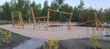 Ahşap yapılar ve kum oyun alanının yer aldığı doğal malzemelerden inşa edilmiş bir çocuk parkı. Çevre dostu, güvenli ve yaratıcı açık hava oyunlarını teşvik etmek için tasarlanmış. Doğa temelli eğitim ve sürdürülebilirlik için ideal