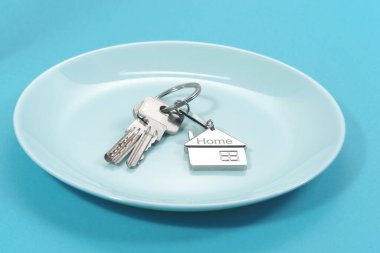 House symbol with silver keys on blue  background. Real estate concept