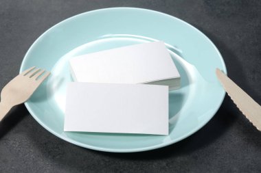 Blank white mock-up business cards, porcelain blue plate on dark backgound table