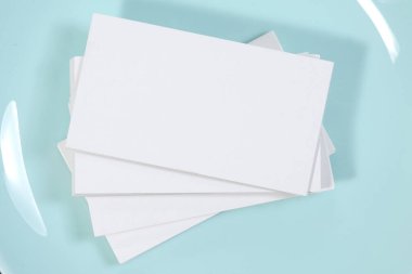 Blank white mock-up business cards, porcelain blue plate on dark backgound table