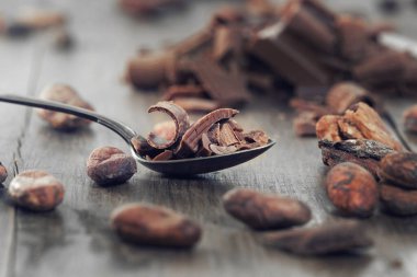 Broken dark chocolate and cocoa beans on a table