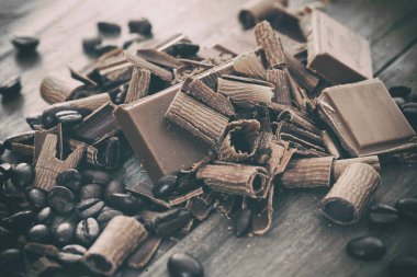 Broken dark chocolate and cocoa beans on a table