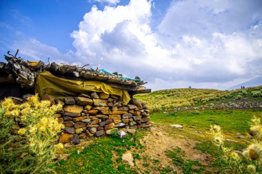 Dağ vadisinde taştan yapılmış çobanın evinin yan görüntüsü.