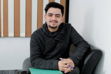 A young employee is sitting on the couch in the office.