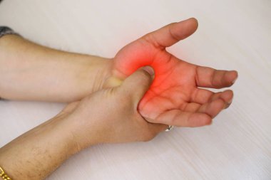 A young man feeling pain in his hand at home. Healthcare and medical concept.