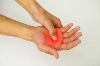 A young man feeling pain in his hand at home. Healthcare and medical concept.