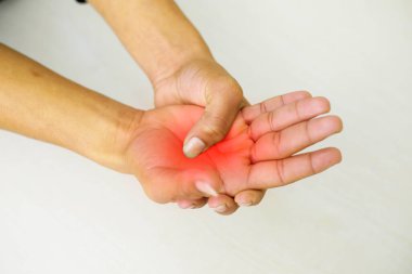 A young man feeling pain in his hand at home. Healthcare and medical concept.