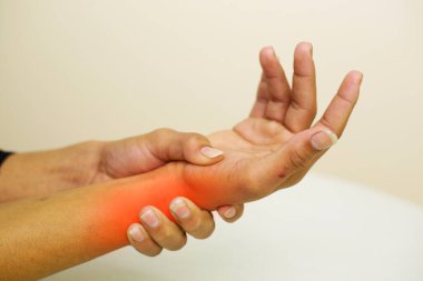 A young man feeling pain in his wrist at home. Healthcare and medical concept.