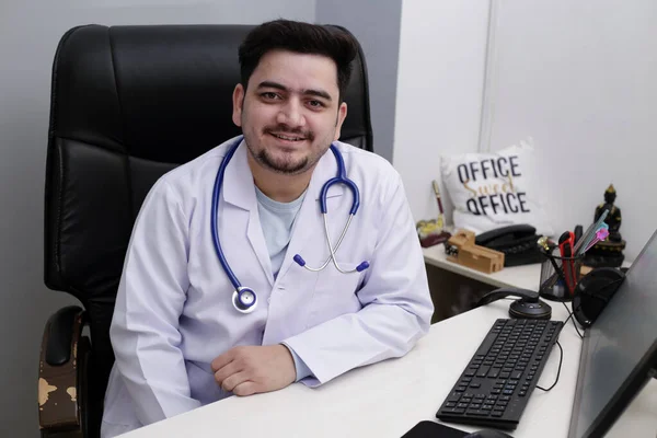 Joven Médico Está Sentado Clínica Sonriendo — Foto de Stock