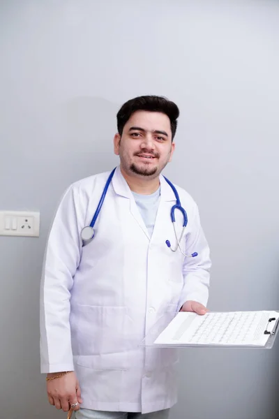 Een Jonge Dokter Staat Houdt Notitieblok Hand Glimlacht — Stockfoto