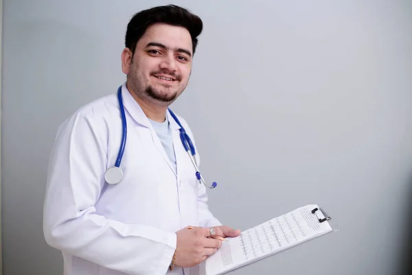 Een Jonge Dokter Staat Houdt Notitieblok Hand Glimlacht — Stockfoto