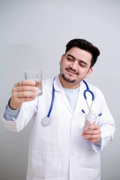 Młody Lekarz Stoi Szklanką Wody Jednej Ręce Butelką Wody Drugiej — Zdjęcie stockowe
