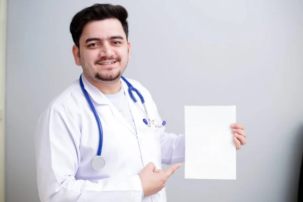 Ein Junger Arzt Steht Und Hält Leeres Papier Der Hand — Stockfoto