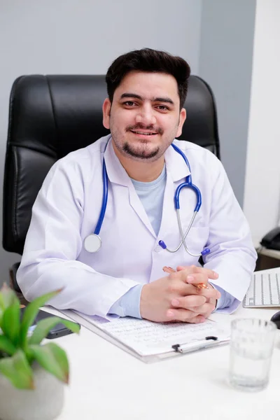 Joven Médico Está Sentado Clínica Sonríe — Foto de Stock