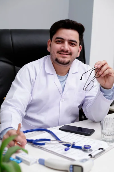 Ein Junger Arzt Sitzt Der Klinik Hält Spezifikationen Der Hand — Stockfoto