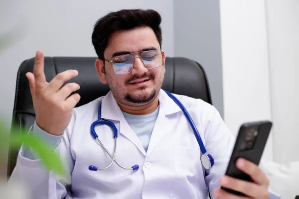 Jovem Médico Está Sentado Clínica Falando Videochamada — Fotografia de Stock