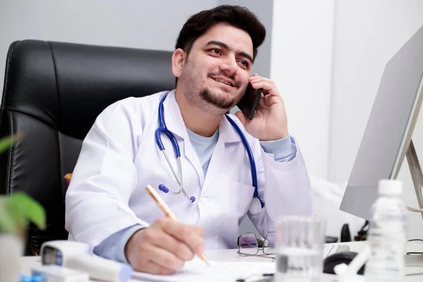 Médico Joven Está Sentado Clínica Hablando Por Teléfono Móvil — Foto de Stock