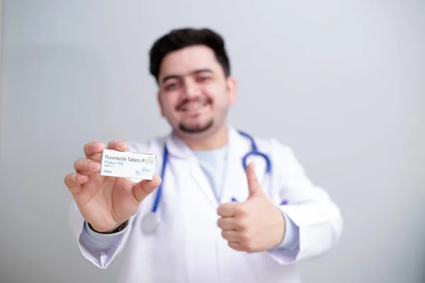 Médico Joven Sostiene Medicina Una Mano Muestra Signo Pulgares Hacia — Foto de Stock
