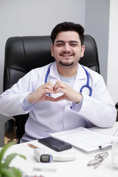 Mladý Doktor Sedí Klinice Dělá Srdce Rukou Usmívá — Stock fotografie