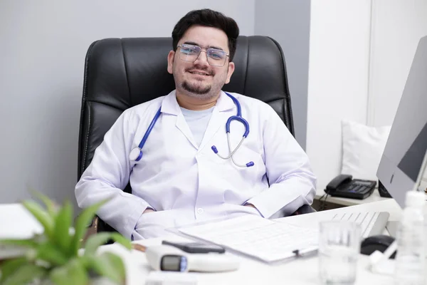 Jovem Médico Está Sentado Clínica Sorrindo — Fotografia de Stock