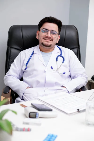 Joven Médico Está Sentado Clínica Sonríe — Foto de Stock