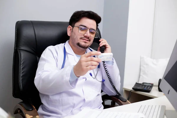 Egy Fiatal Orvos Klinikán Telefonon Beszél Gyógyszert Tart Kezében — Stock Fotó
