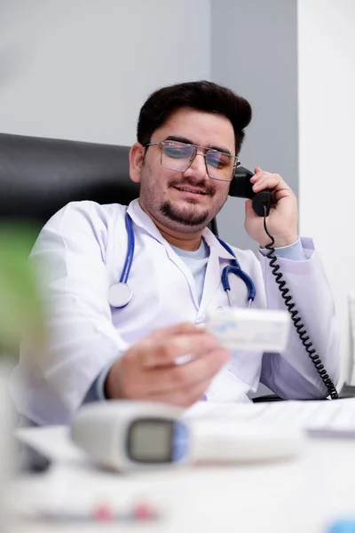 Egy Fiatal Orvos Klinikán Telefonon Beszél Gyógyszert Tart Kezében — Stock Fotó