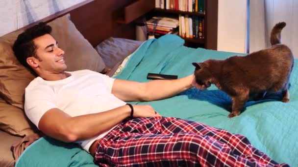 Bonito Jovem Amante Animais Uma Cama Abraçando Abraçando Seu Gato — Vídeo de Stock