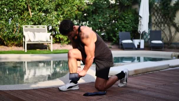 Attractive Young Man Strapping Weights His Ankles Exercise Workout Outdoor — Vídeo de Stock