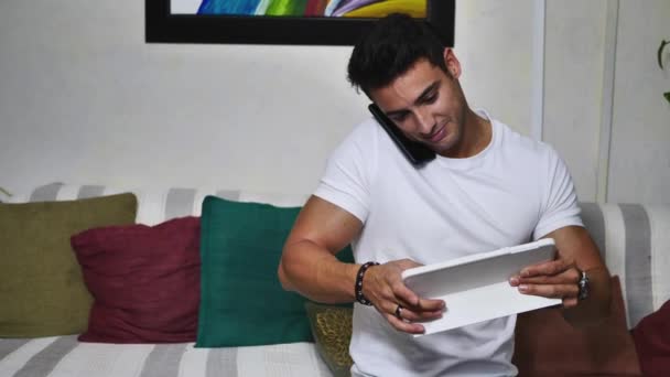Fešák Mladý Muž Ohromen Technologií Pomocí Notebooku Tablet Telefony Doma — Stock video
