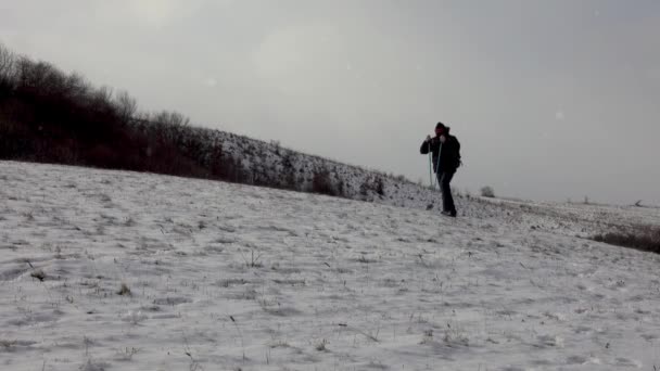 雪の吹雪の中を歩く男 寒い冬のトレッキング 歩く男性 — ストック動画