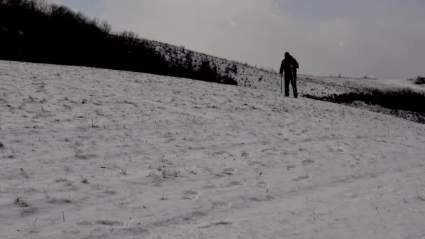 雪の吹雪の中を歩く男 寒い冬のトレッキング 歩く男性 — ストック動画